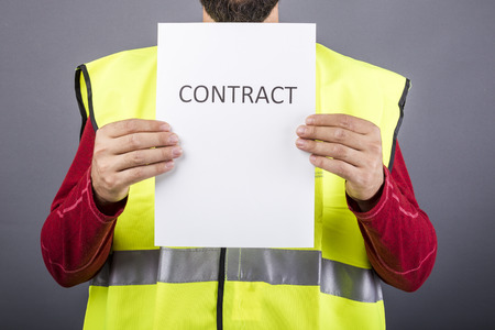 Closeup of a worker holding a contract over gray backgroundの写真素材