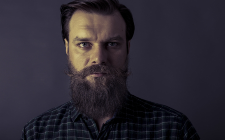 Studio shot of a handsome stylish man with beard and mustacheの写真素材