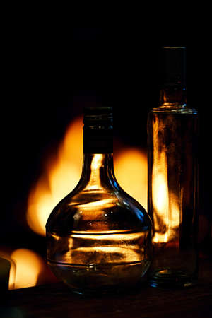 Glass bottles in front of a fireplaceの写真素材