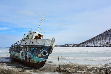 Rusty old abandoned ship on the shore of the frozen lake Baikalの写真素材
