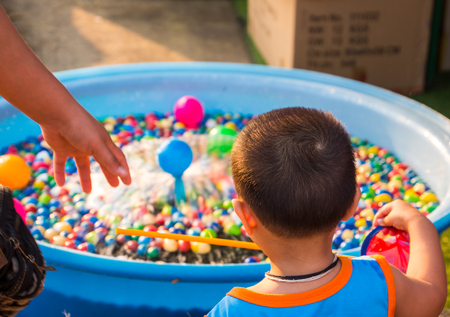 Kid is choosing the ball in the basin.の写真素材