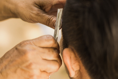 Male client getting haircut by razor.の写真素材