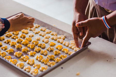 Student 's hands make Singapore cookies from dough in school.の写真素材