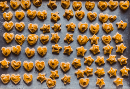 Heart and star shaped cookies on a tray made by students in schoolの写真素材