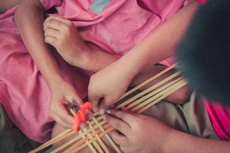 Closeup to hand of Thai students grade 4 in primary school are weaving pattern thai.の写真素材