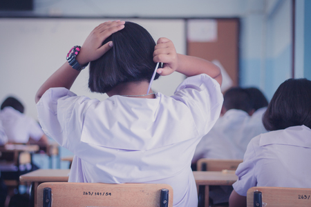 Female students is combing her hair in classroom.の写真素材