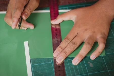 Close-up to hands of students are cutting  prints and stickers  using knife cutter.の写真素材
