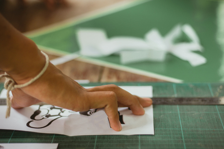 Close-up to hands of students are cutting  prints and stickers  using knife cutter.の写真素材