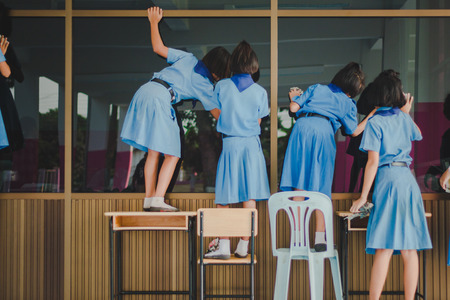 Students are helping to wipe the glass.の写真素材