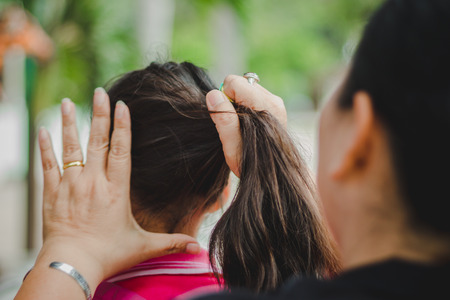 The teacher prepares the student's hair before returning home.の写真素材