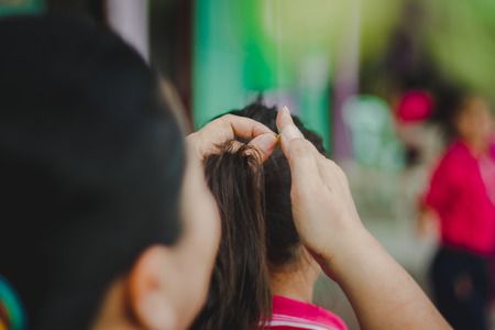 The teacher prepares the student's 
hair before returning home.の写真素材