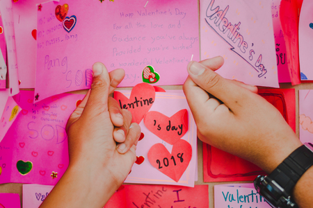 Secondary school students make Valentine cards on a board.の写真素材