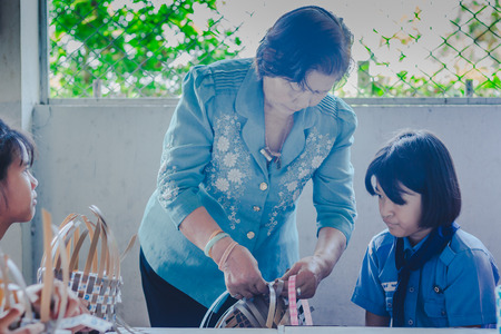 KANCHANABURI THAILAND - FEBRUARY 21 : Unidentified Local instructors teach Thai handicrafts to unidentified students on february 21,2018 at Wat Krang Thong School in Kanchanaburi, Thailandのeditorial素材