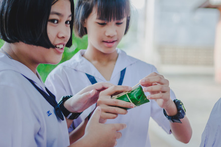 KANCHANABURI THAILAND - FEBRUARY 22 : Unidentified studentslearn to make bananas with sticky rice on february 20,2018 at Wat Krang Thong School in Kanchanaburi, Thailandのeditorial素材