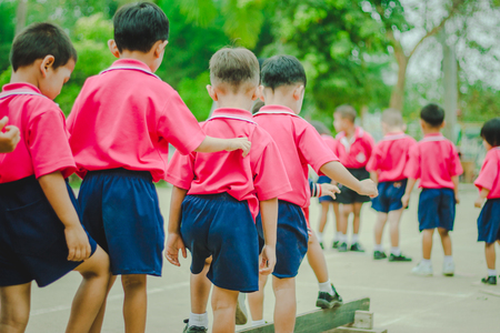 Happy Kindergarten students are exercising in morning.