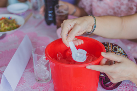 Close-up th hands add ice to the glass to distribute to friends at the table on party of Graduation.の写真素材