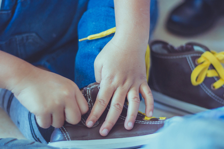 Kid is tying shoes laces before stage show in schoolの写真素材