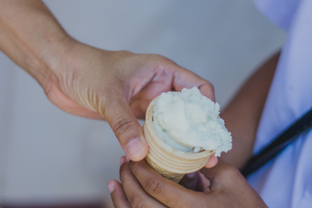 Close-up to Teacher 's hands give ice cream to students.の写真素材