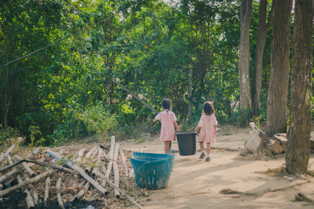 Students help to remove rubbish from the classroom to pile wasteの写真素材