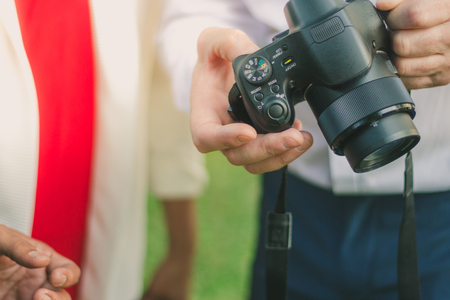 Business man settings a camera for friend to take a photoの写真素材