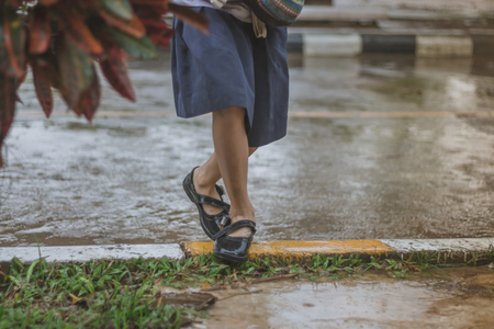 Students walk to the flood after rain in school.の写真素材