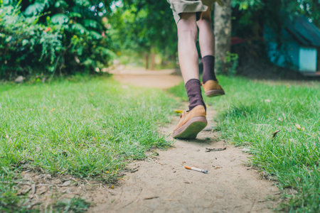Smoking student is running away from his teacherin school. Selective focus on cigarette.の写真素材