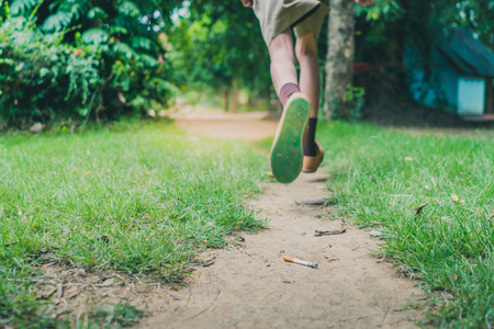 Smoking student is running away from his teacherin school. Selective focus on cigarette.の写真素材
