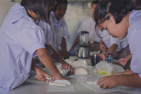 KANCHANABURI THAILAND - JUNE 21 : Unidentified students 
confederate to make dumplings in coconut cream on June 21,2018 at Watkrangthongratburana school in Kanchanaburi, Thailandのeditorial素材