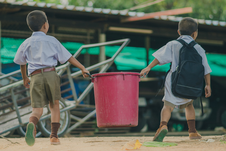 Students help to remove rubbish from the classroom to pile waste.の写真素材