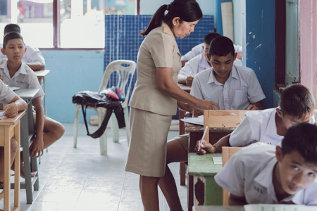 KANCHANABURI THAILAND - JULY 16 :  Unidentified Good teacher give midterm exam questions to students in the classroom on July 16,2018 at Watkrangthongratburana school in Kanchanaburi, Thailandのeditorial素材