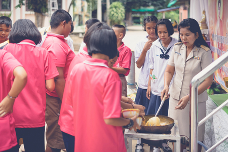 KANCHANABURI THAILAND - JULY 23 :  Unidentified Teacher and students join melting cast candle offer to temple in traditional lent candle festival for Buddhist Lent Day on July 23,2018 at Watkrangthongratburana school in Kanchanaburi, Thailandのeditorial素材
