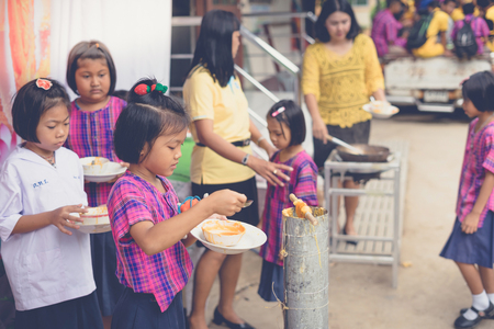 KANCHANABURI THAILAND - JULY 24 :  Unidentified Teacher and students join melting cast candle offer to temple in traditional lent candle festival for Buddhist Lent Day on July 24,2018 at Watkrangthongratburana school in Kanchanaburi, Thailandのeditorial素材