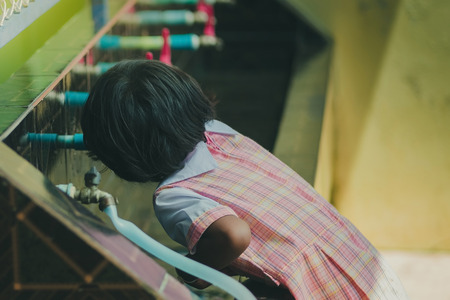 Students drinking water from the faucet after lunch.の写真素材