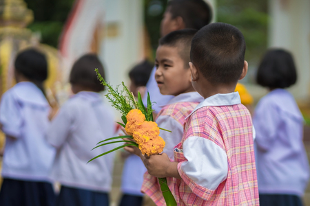 KANCHANABURI THAILAND - JULY 26 : Unidentified Teachers and students  together to make merit and candle light on Buddhist lent day on July 26,2018 at Wat Krang Thong in Kanchanaburi, Thailandのeditorial素材