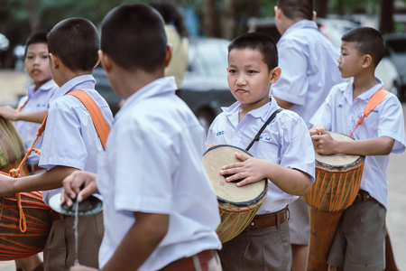KANCHANABURI THAILAND - JULY 26 : Unidentified teacher and students  participated for Buddhist Lent Day in buddhist culture at Watkrangthongratburana by play a tall narrow drum or called "Tom-Tom" on July 26,2018 at  in Kanchanaburi, Thailandのeditorial素材