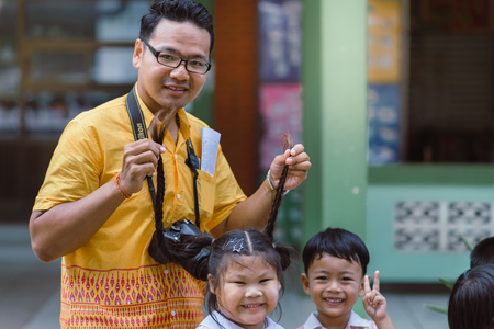 KANCHANABURI THAILAND - JULY 26 : Unidentified teacher and students waited for time to go to temple in traditional lent candle festival for Buddhist Lent Day on July 26,2018 at Watkrangthongratburana school in Kanchanaburi, Thailandのeditorial素材