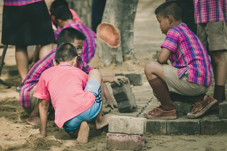 KANCHANABURI THAILAND - OCTOBER 2 :  Unidentified Teachers and students are helping to build a brick pathway in the garden on October 2,2018 at Watkrangthongratburana school in Kanchanaburi, Thailandのeditorial素材