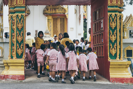 KANCHANABURI THAILAND - JULY 26 : Unidentified Teachers and students  together to make merit and candle light on Buddhist lent day on July 26,2018 at Wat Krang Thong in Kanchanaburi, Thailandのeditorial素材