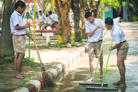 KANCHANABURI THAILAND - OCTOBER 8 : Unidentiffied Students help to clean the streets after heavy rain on October 8,2018 at Watkrangthongratburana school in Kanchanaburi, Thailandのeditorial素材