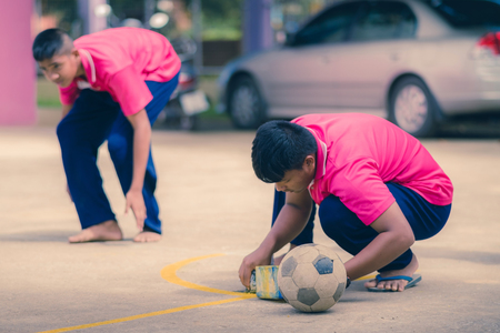 KANCHANABURI THAILAND - SEPTEMBER 20 :  Unidentified students help to build a sepak takraw field border on the cement floor on September 20,2018 at Watkrangthongratburana school in Kanchanaburi, Thailand.のeditorial素材
