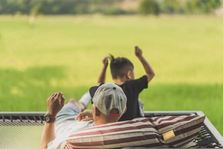 Dad and son relax on the balcony with a beautiful rice fields.のeditorial素材