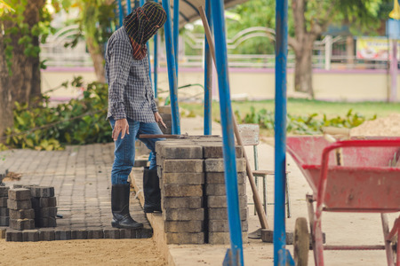 School janitor builds a brick pathway in school