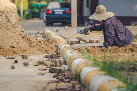 School janitor builds a brick pathway in schoolのeditorial素材