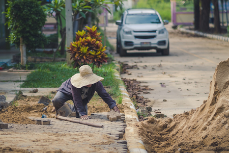 School janitor builds a brick pathway in schoolのeditorial素材