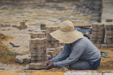 School janitor builds a brick pathway in schoolのeditorial素材