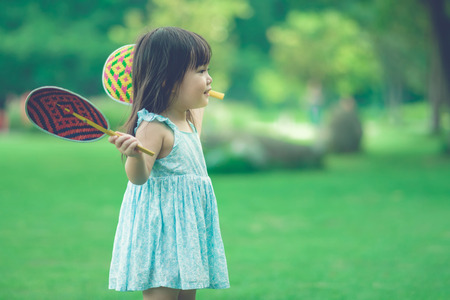 KANCHANABURI THAILAND - OCTOBER 28 : Unidentified litlle girl enjoy with Thai weave colorful fan handle at field on October 28,2018 in Kanchanaburi, Thailand.のeditorial素材