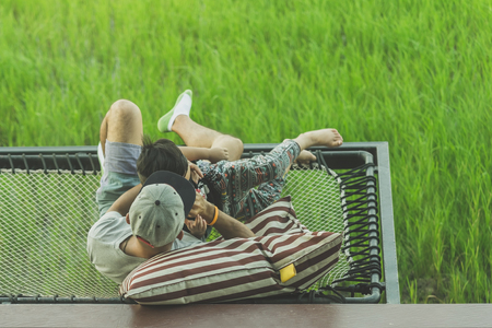 Dad and son relax on the balcony with a beautiful rice fields.の写真素材