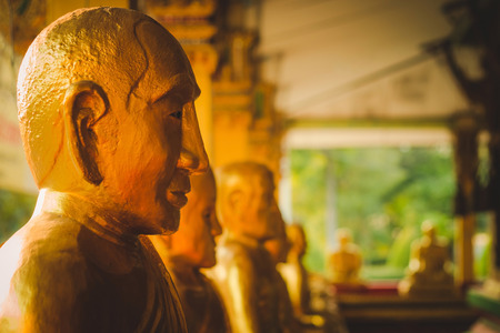 A row of golden buddha statue at Wat Intharam Kanchanaburi, Thailand.の写真素材