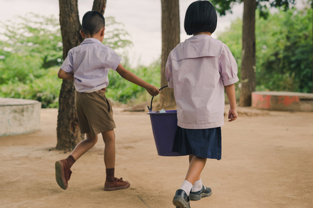 Students help to remove rubbish from the classroom to pile waste in school.の写真素材