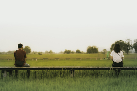 Asian people relax and take a photography on wooden bridge in the rice field in eveningの写真素材